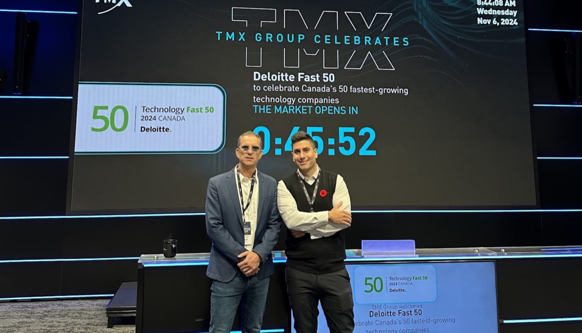 Scott Satov and Cris Ravazzano standing on the TMX Group stage in Toronto, in front of a screen celebrating the Deloitte Technology Fast 50, 2024.